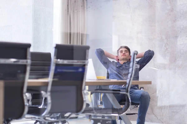 Young businessman relaxing at the desk — Stock Photo, Image