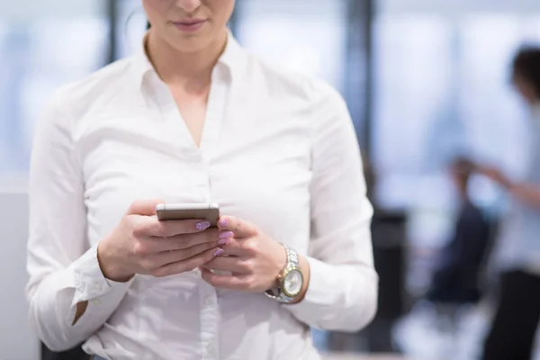 Elegancka kobieta przy użyciu telefonu komórkowego w budynku biurowym uruchamiania — Zdjęcie stockowe