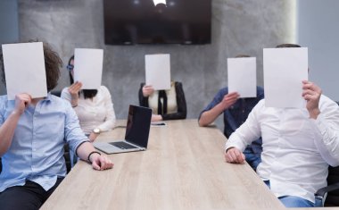 başlangıç iş ekibi beyaz bir kağıt yüz üzerinde tutarak