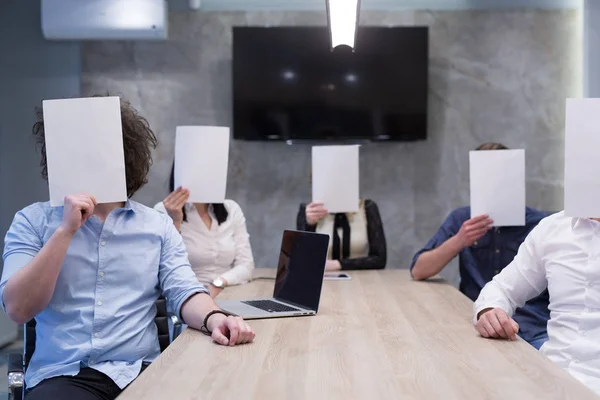 Equipo de empresas emergentes que sostiene un libro blanco sobre la cara —  Fotos de Stock