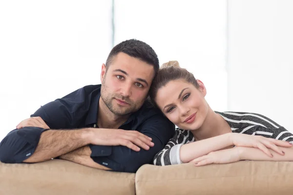 Portret młoda para siedzi na kanapie — Zdjęcie stockowe