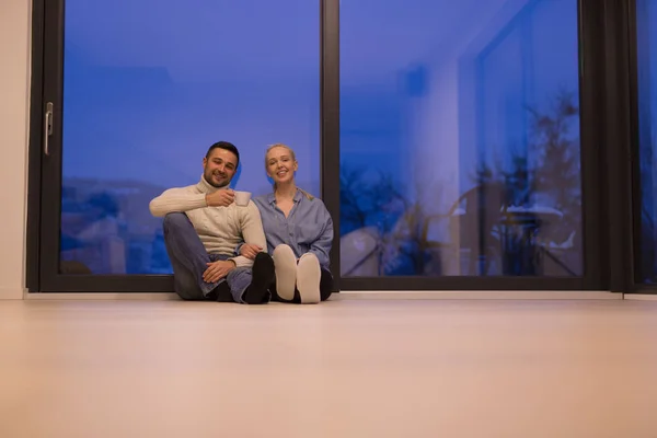 Casal sentado no chão na frente da lareira — Fotografia de Stock