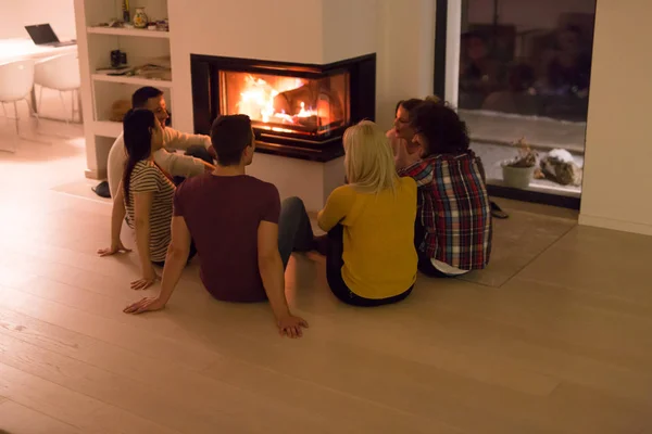 Grupo Jóvenes Parejas Multiétnicas Sentadas Suelo Frente Chimenea Fría Noche —  Fotos de Stock