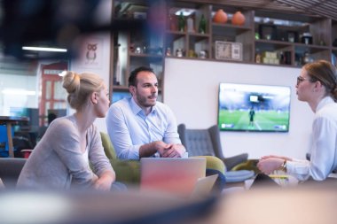 Bir grup genç iş adamı modern ofis binasında iş planlarını tartışıyor