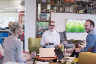 Bir grup genç iş adamı modern ofis binasında iş planlarını tartışıyor