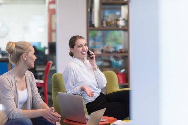 Bir grup genç iş adamı modern ofis binasında iş planlarını tartışıyor