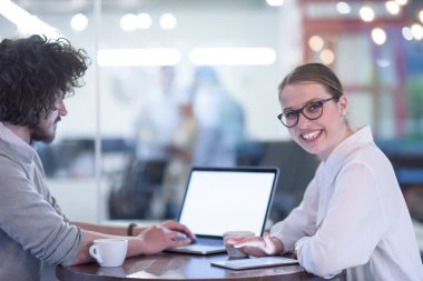 Bir sonraki toplantı için dizüstü bilgisayar kullanan girişimciler kahve içerken ve yaratıcı ofiste fikirleri tartışırken...