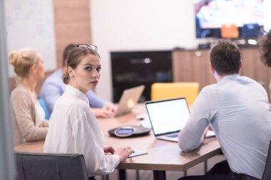 Bir grup genç iş adamı modern ofis binasında iş planlarını tartışıyor