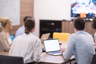 Bir grup genç iş adamı modern ofis binasında iş planlarını tartışıyor