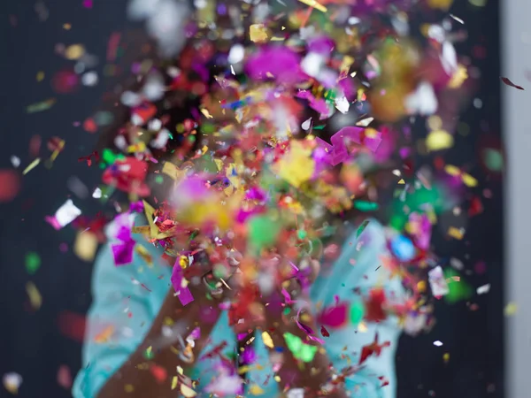 Svart kvinna blåser konfetti i luften — Stockfoto