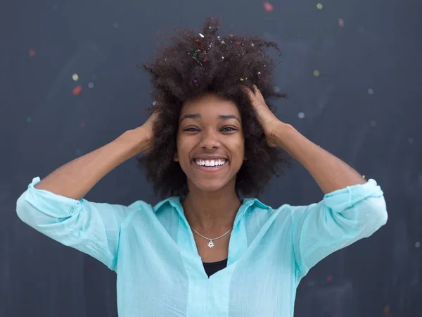 Černá žena fouká konfety ve vzduchu — Stock fotografie