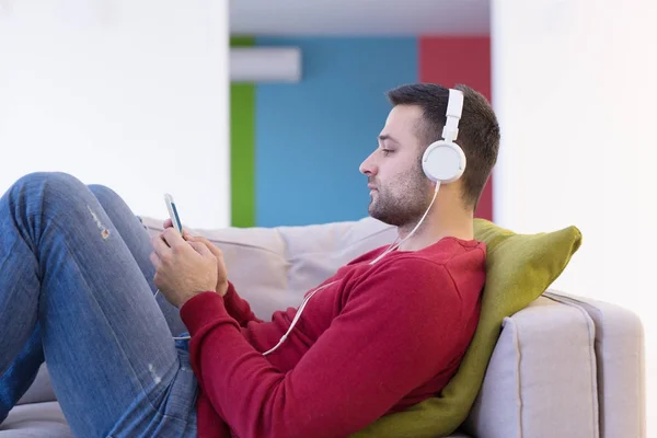 Jonge man genieten van muziek via de koptelefoon — Stockfoto