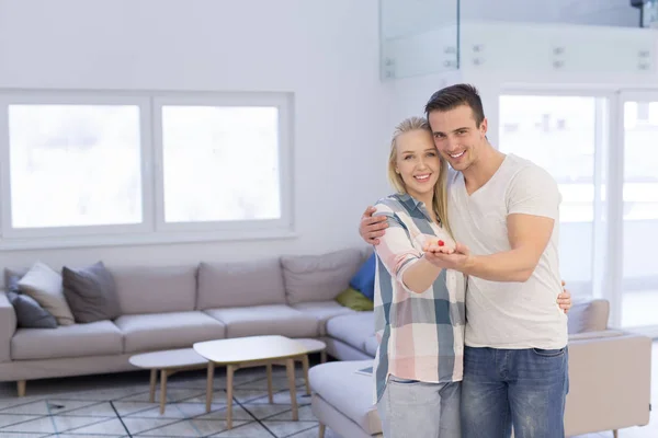 Casal mostrando pequena casa vermelha — Fotografia de Stock