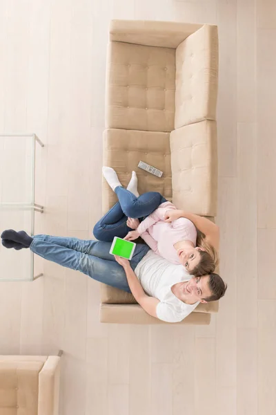 Jovem casal sentado no sofá — Fotografia de Stock