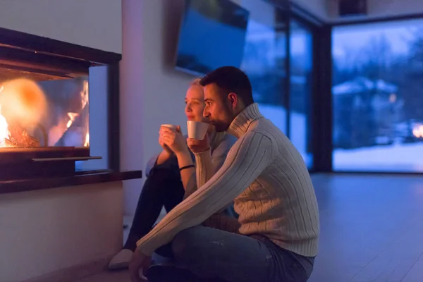 Feliz pareja delante de la chimenea —  Fotos de Stock