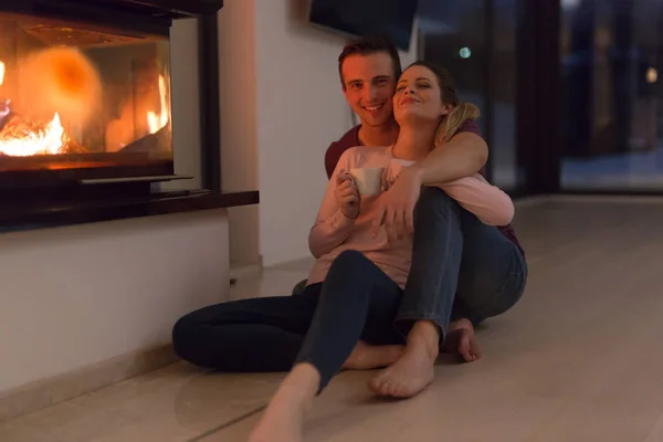 Casal feliz na frente da lareira — Fotografia de Stock