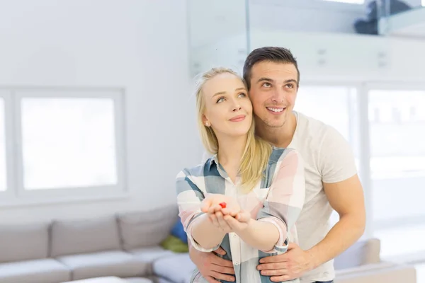 Casal mostrando pequena casa vermelha — Fotografia de Stock