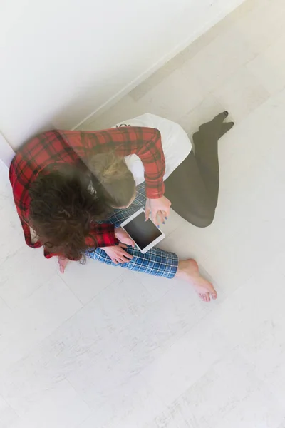 Pareja sentada en el suelo y usando internet — Foto de Stock