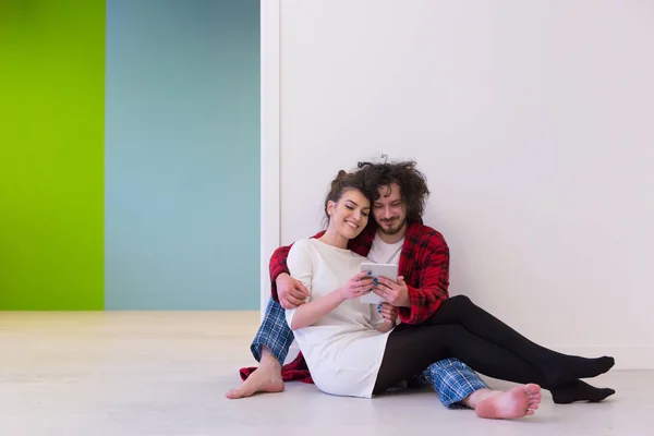 Paar zittend op de vloer en het gebruik van internet — Stockfoto