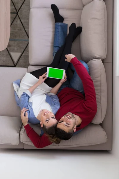 Ouple χαλαρώνοντας στο σπίτι χρησιμοποιώντας tablet — Φωτογραφία Αρχείου