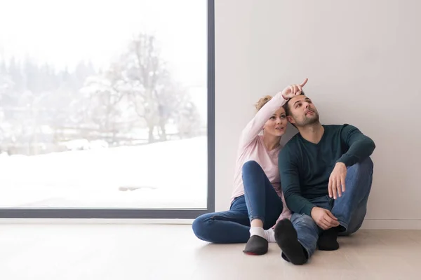 Mladý pár sedící na podlaze okna doma — Stock fotografie