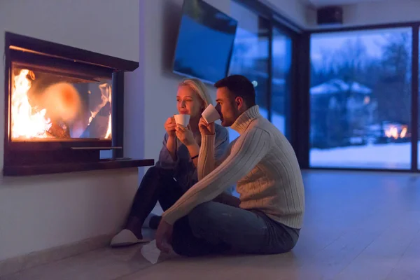 Feliz pareja delante de la chimenea —  Fotos de Stock