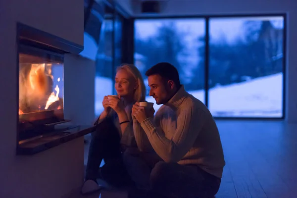 Happy couple in front of fireplace — Stock Photo, Image