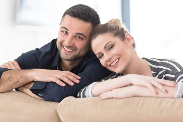 Retrato de pareja joven sentada en el sofá — Foto de Stock