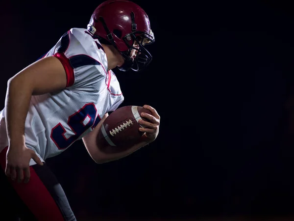 American football speler bal te houden terwijl u op een veld uitvoert — Stockfoto