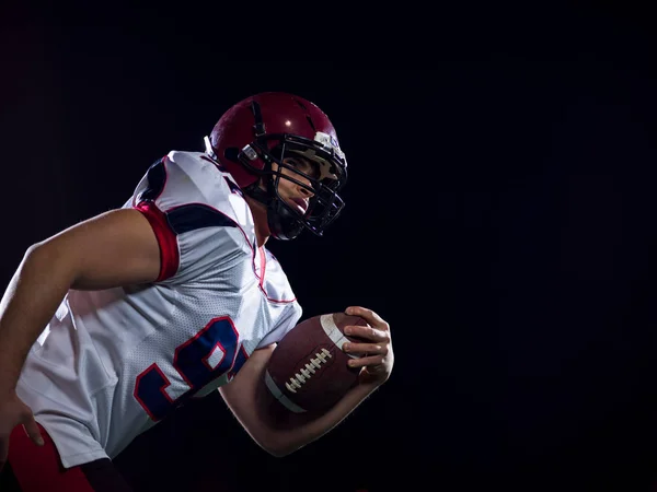 American football speler bal te houden terwijl u op een veld uitvoert — Stockfoto