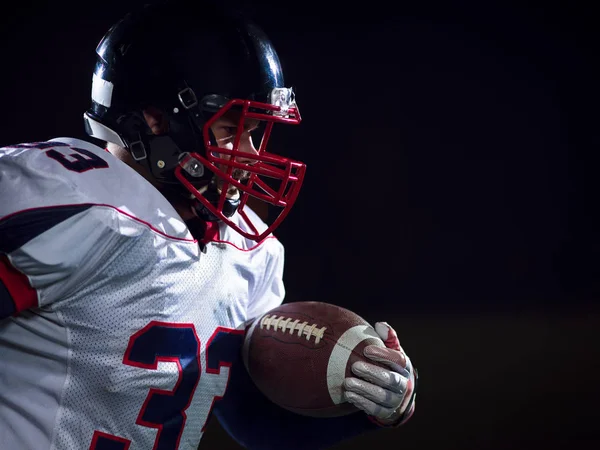 American football speler bal te houden terwijl u op een veld uitvoert — Stockfoto