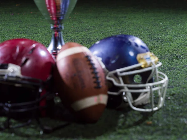 Крупный план американского футбола, шлемов и трофеев — стоковое фото