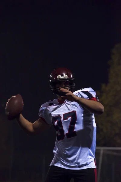 Joueur de football américain lançant un ballon de rugby — Photo