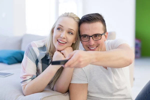 Young couple on the sofa watching television — Stock Photo, Image