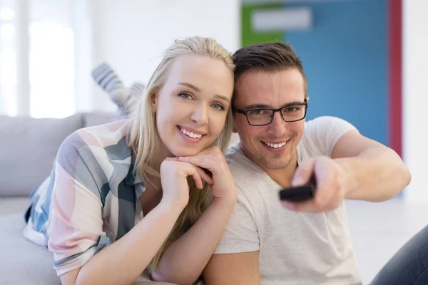 Pareja joven en el sofá viendo la televisión — Foto de Stock