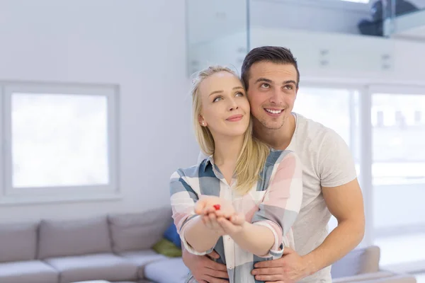 Casal mostrando pequena casa vermelha nas mãos — Fotografia de Stock