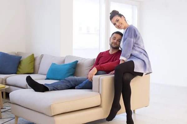 Casal abraçando e relaxando no sofá — Fotografia de Stock