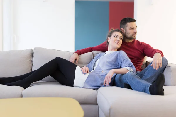 Casal abraçando e relaxando no sofá — Fotografia de Stock