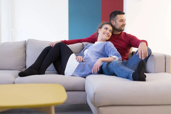 Casal abraçando e relaxando no sofá — Fotografia de Stock