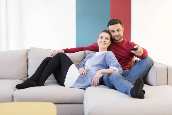 Νεαρό ζευγάρι στον καναπέ βλέποντας τηλεόραση — Φωτογραφία Αρχείου