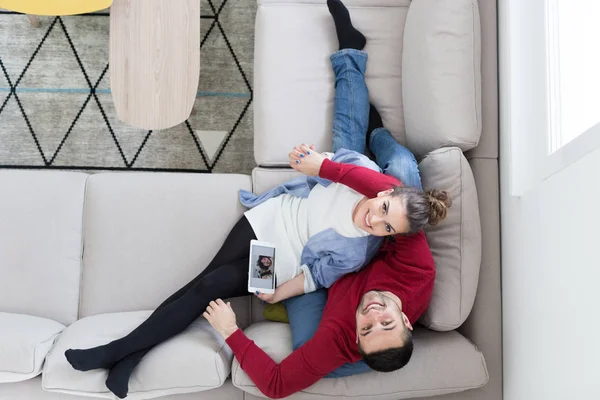 Couple relaxant à la maison avec tablettes — Photo