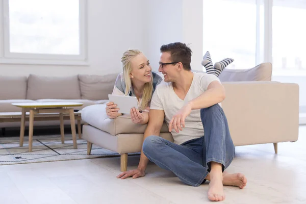 couple relaxing at  home with tablet computers