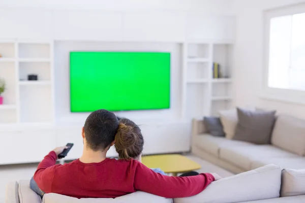 Jovem casal no sofá assistindo televisão — Fotografia de Stock