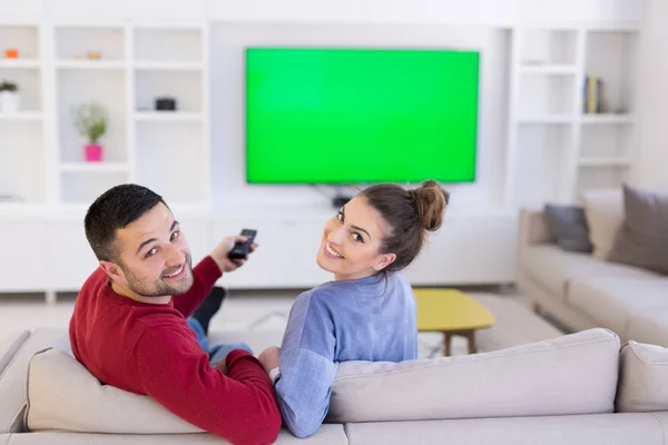 Pareja joven en el sofá viendo la televisión — Foto de Stock