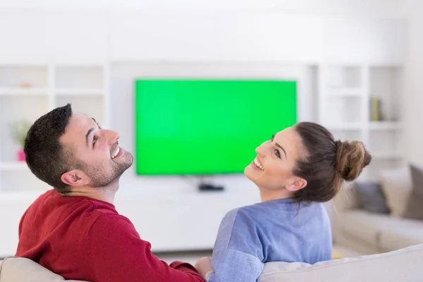 Jeune couple sur le canapé regarder la télévision — Photo