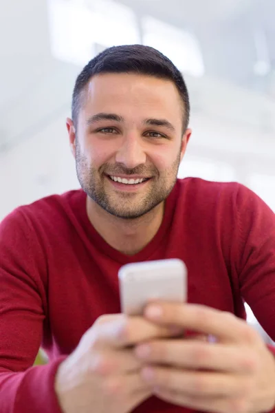 Giovane utilizzando un telefono cellulare a casa — Foto Stock