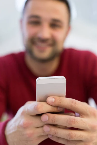 Joven usando un teléfono móvil en casa —  Fotos de Stock