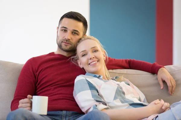 Casal abraçando e relaxando no sofá — Fotografia de Stock