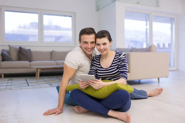 年轻夫妇在地板上使用数字平板电脑 — 图库照片