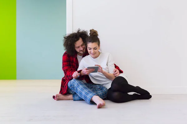 Jeune couple utilisant une tablette numérique sur le sol — Photo